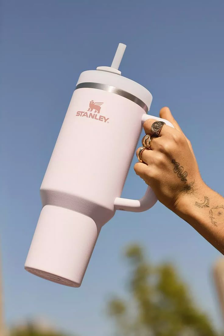 Pink handled tumbler with a straw against a blue sky