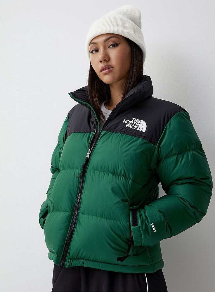 Model wearing a green puffer jacket and a white beanie